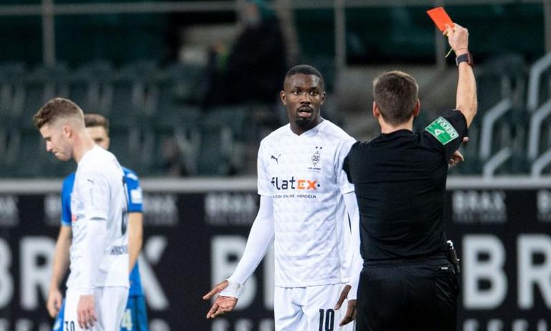 Moenchengladbach forward Marcus Thuram is shown a red card for spitting at an opponent on Saturday