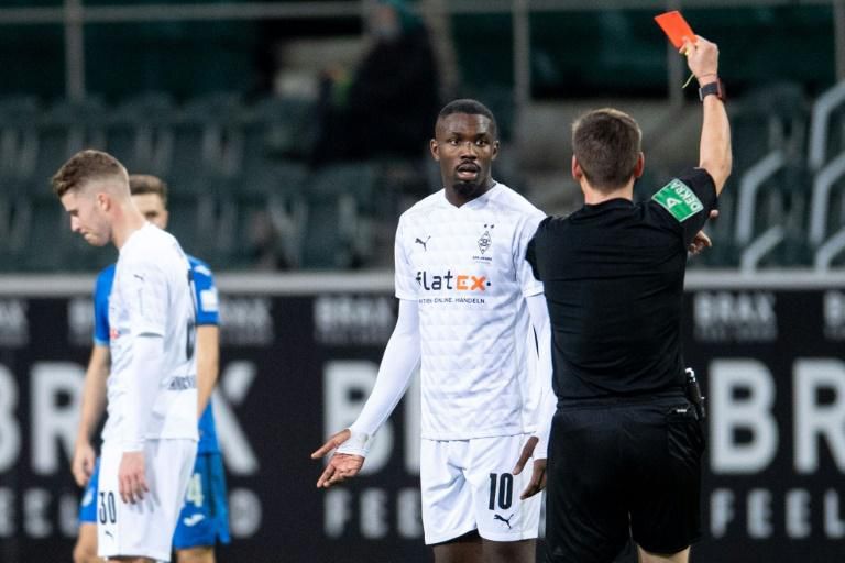 Moenchengladbach forward Marcus Thuram is shown a red card for spitting at an opponent on December 19, 2020.