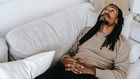 Pensive black man lying on couch [Photo: Alex Green]