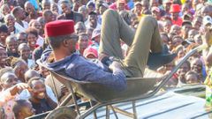 [FILE] Kimilili MP Didmus Barasa in a previous rally trying to woo voters by climbing into a wheelbarrow that was placed on top of his vehicle. The wheelbarrow is his party symbol