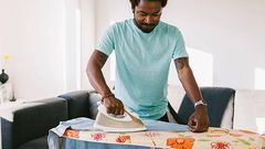 A photo of a man ironing clothes