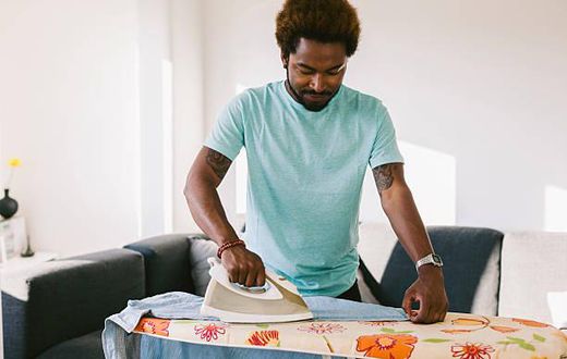 A photo of a man ironing clothes