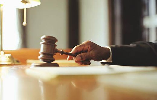 A photo of a judge striking gavel in a courtroom