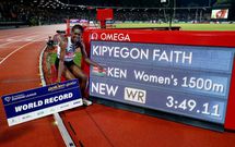 Faith Kipyegon poses with the screen as she sets a new world record and wins the women's 1500m final REUTERS/Remo Casilli