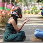 Photo of a couple wearing helmets, sitting on a pavement in a park [Image Credit: Professional QP]