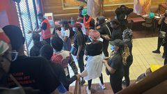 Anti Finance Bill 2024 protestors take cover inside a restaurant in Nairobi