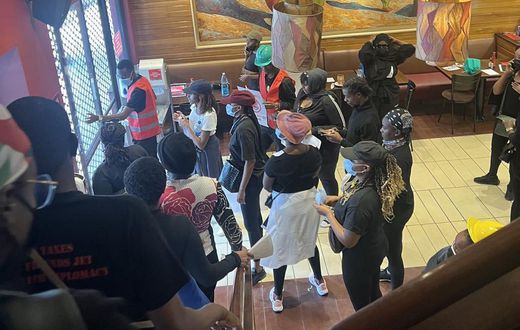 Anti Finance Bill 2024 protestors take cover inside a restaurant in Nairobi
