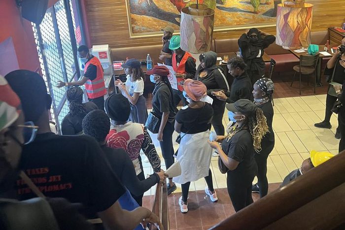 Anti Finance Bill 2024 protestors take cover inside a restaurant in Nairobi