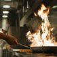Chef holding flaming pan