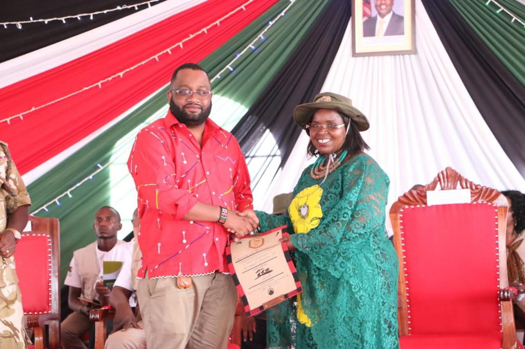 Calmilus Ondego from Grain Bulk Handlers receives a cerfiticate from CS Peninah Molonza  after the organisation adopted an elephant during the Magical Kenya Tembo Naming Festival