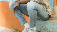 A young man seated in a park thinking