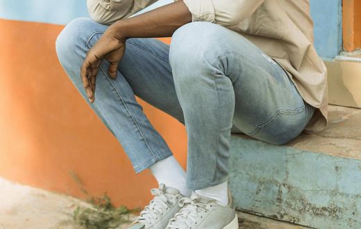 A young man seated in a park thinking