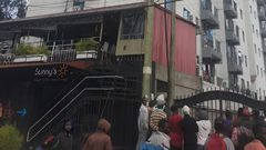 A crowd outside an apartment where a woman was died after reportedly being thrown from one of the houses