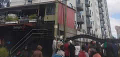 A crowd outside an apartment where a woman was died after reportedly being thrown from one of the houses