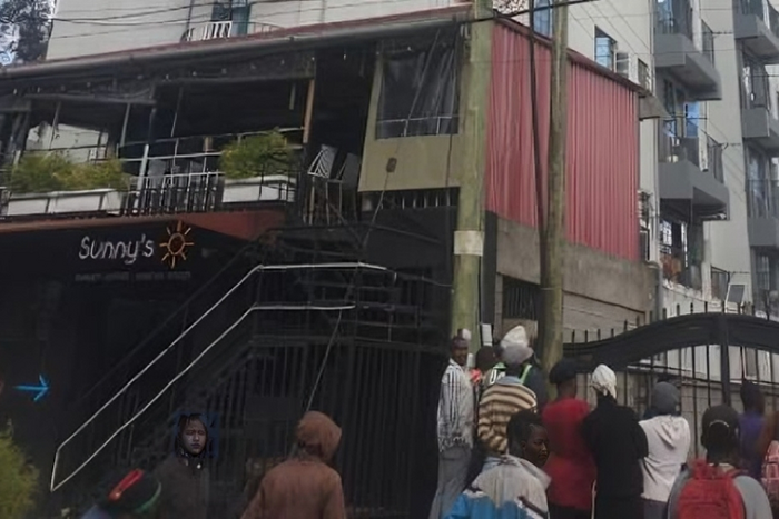 A crowd outside an apartment where a woman was died after reportedly being thrown from one of the houses