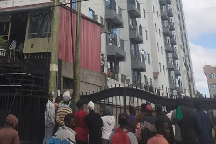 A crowd outside an apartment where a woman was died after reportedly being thrown from one of the houses