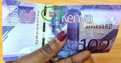 A woman holds new Kenyan currency Sh100 note. CBK settles "Banki" and "Benki" debate once and for all
