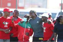 Young athletes pose for a photo with Africa 100m champion Ferdinand Omanyala