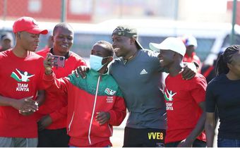 Young athletes pose for a photo with Africa 100m champion Ferdinand Omanyala