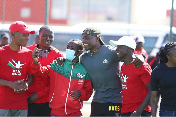 Young athletes pose for a photo with Africa 100m champion Ferdinand Omanyala