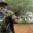 Kenya police officers stand guard as the bodies of suspected members of a Christian cult named as Good News International Church are exhumed in Shakahola forest in Kenya, April 22, 2023.Stringer/Reuters