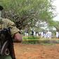 Kenya police officers stand guard as the bodies of suspected members of a Christian cult named as Good News International Church are exhumed in Shakahola forest in Kenya, April 22, 2023.Stringer/Reuters