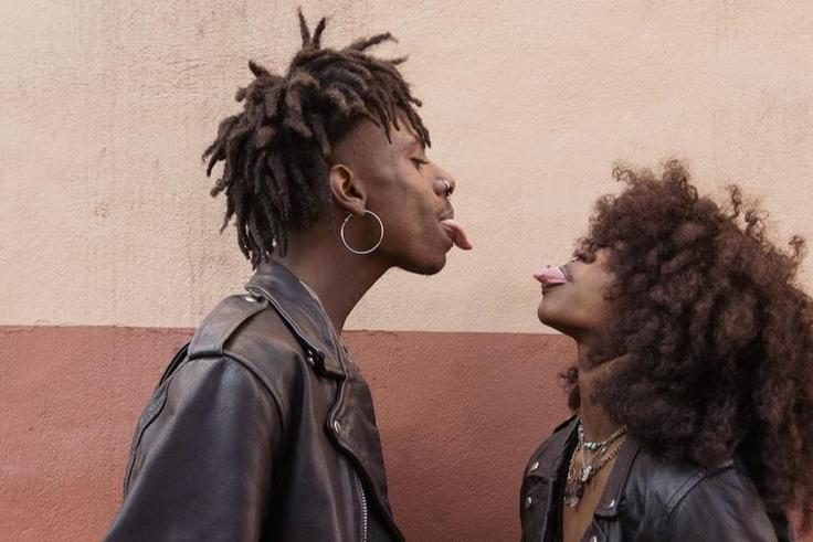 Young couple standing face to face and sticking out tongues [Image: Brian Jr Asare]