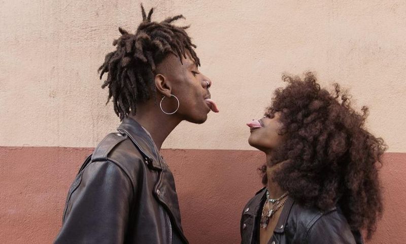 Young couple standing face to face and sticking out tongues [Image: Brian Jr Asare]