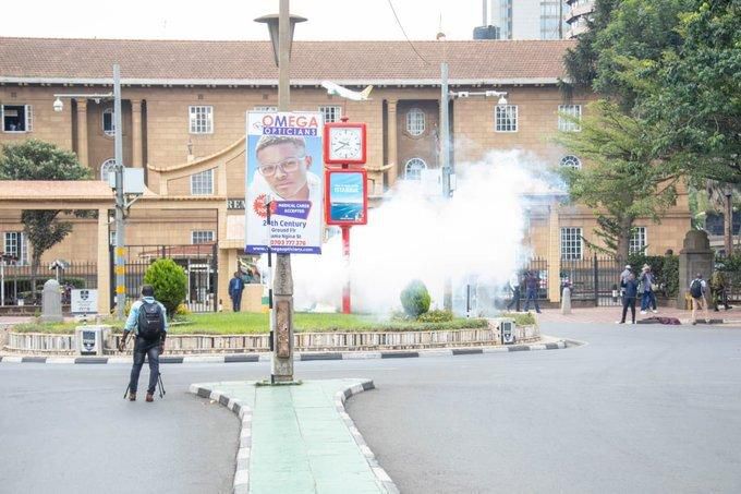 A journalist stares at a launched tear gas