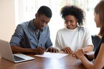 A young couple signing documents