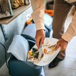 Man throwing left over food to a dustbin