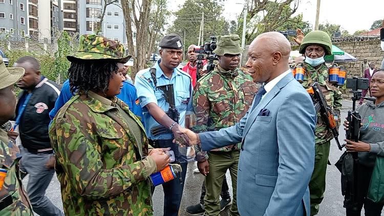 File image of former Mungiki leader Maina Njenga chats with police officers outside the Nakuru Law Courts building on Tuesday, November 21, 2023