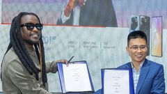 CAMON 20 series Brand Ambassador, Nyashinski and TECNO Kenya Brand Manager, Peter Shi show off a signed copy of the contract during the unveil event held at the Social House on May 9, 2023