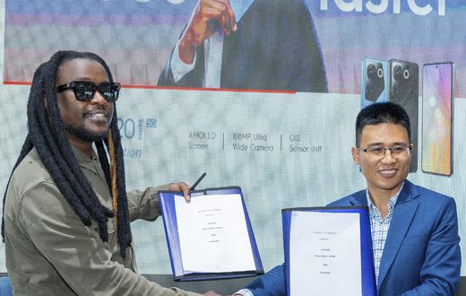 CAMON 20 series Brand Ambassador, Nyashinski and TECNO Kenya Brand Manager, Peter Shi show off a signed copy of the contract during the unveil event held at the Social House on May 9, 2023