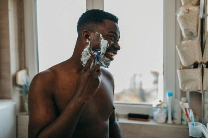 Photo of a man shaving his beard