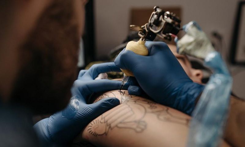 Tattoo artist tattooing a client's arm [Photo: Pavel Danilyuk]