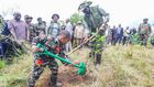 President William Ruto planting a tree alongside a young boy during the National Tree Planting Day in Murang'a County on May 10, 2024