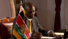 President William Ruto signs a document at State House