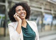 Photo of a young woman speaking on her mobile phone in the street