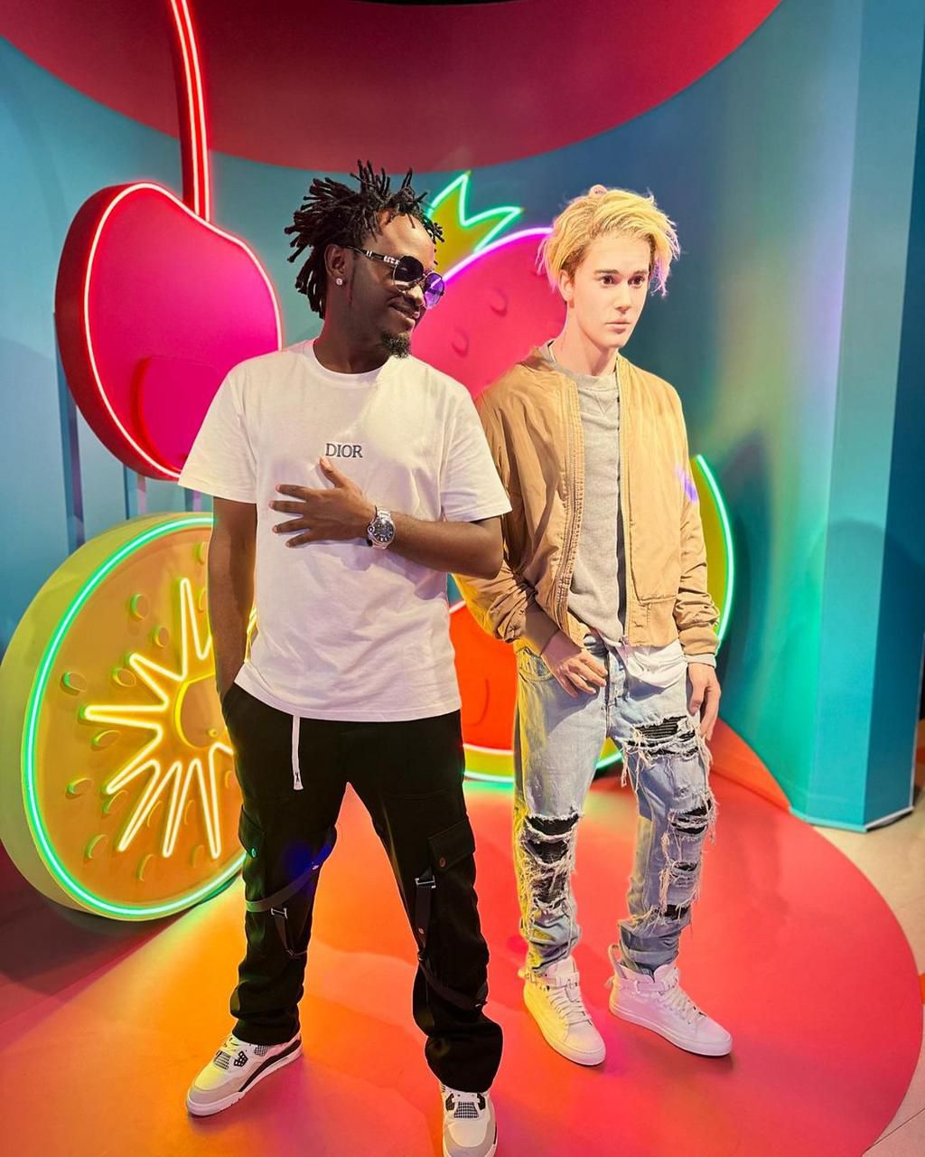 Singer Bahati posing next to the wax statue of pop singer Justin Bieber at Madame Tussauds Museum, Singapore