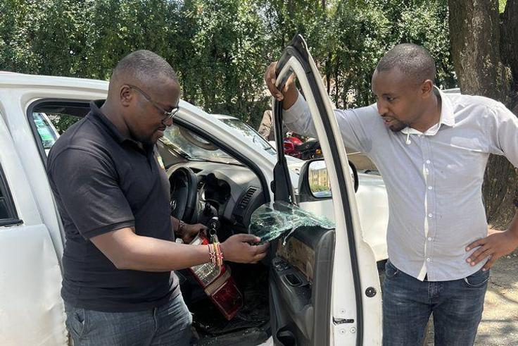 Seth Olale looks at the shattered windows of Citizen TV vehicle