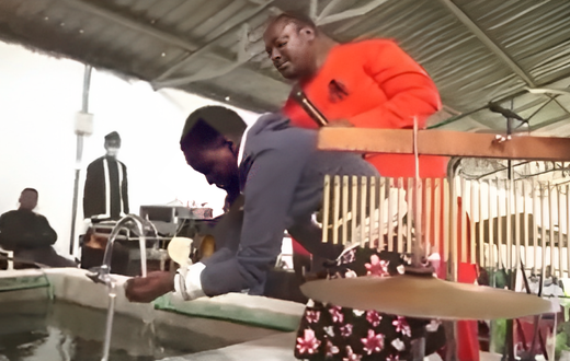 Pastor Kanyari directing one of his follower to wash her face and drink water from his newly built 'Bethsaida' pool