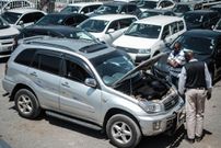 Customers check cars at a used car shop in Nairobi on October 4, 2017. (Photo by YASUYOSHI CHIBA/AFP via Getty Images)