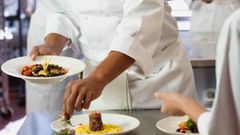 A chef garnishing a meal