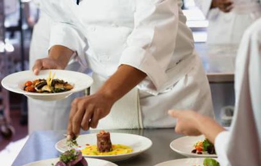 A chef garnishing a meal