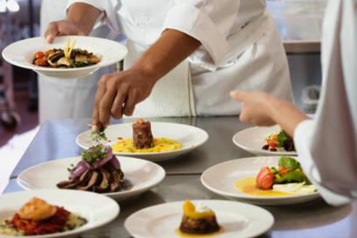 A chef garnishing a meal