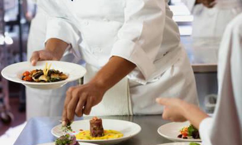 A chef garnishing a meal