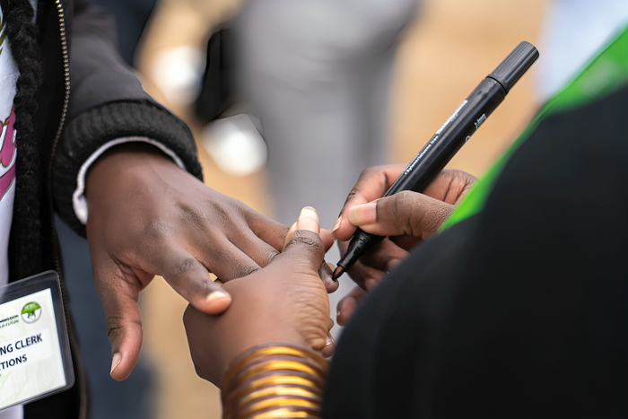 An election official marks the nail of a voter to indicate they have cast their ballots and completed voting at a polling station in the Mathare neighborhood of Nairobi. Photo Credit: Nickolai Hammar/NPR