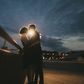 Caucasian couple kissing near railing at night
