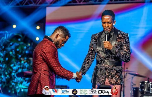 Diamond Platnumz being prayed for by a preacher
